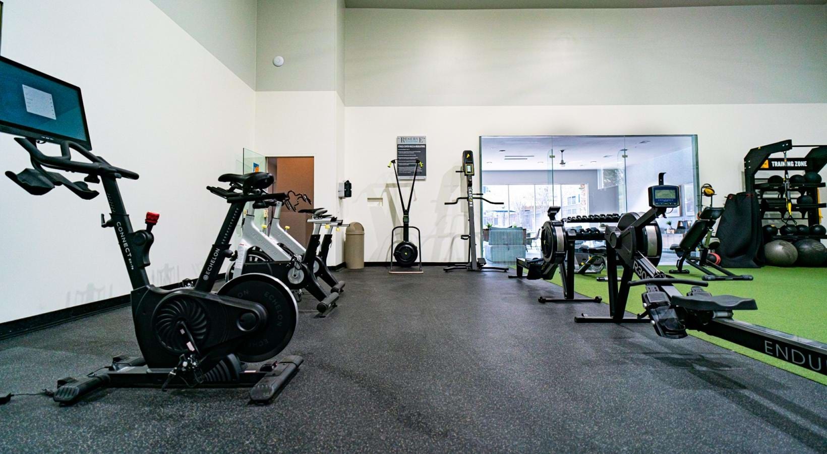 Quick access to state-of-the-art amenities exercise machines in brightly lit fitness center