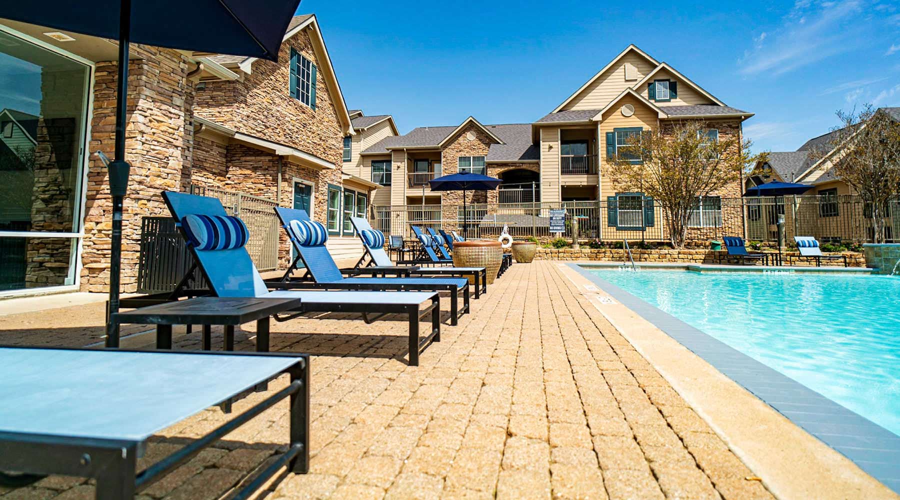 Discover Luxury Living in Austin umbrella shaded lounge chairs next to pool